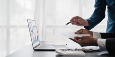 Business People Meeting using laptop computer,calculator,notebook,stock market chart paper for analysis Plans to improve quality next month. Conference Discussion Corporate Concept..