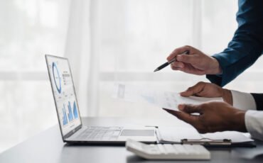 Business People Meeting using laptop computer,calculator,notebook,stock market chart paper for analysis Plans to improve quality next month. Conference Discussion Corporate Concept..