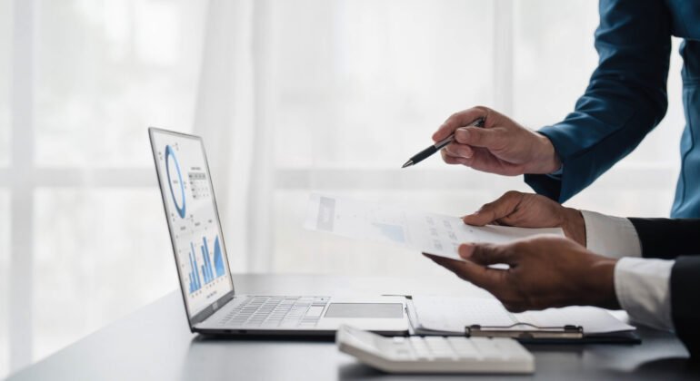 Business People Meeting using laptop computer,calculator,notebook,stock market chart paper for analysis Plans to improve quality next month. Conference Discussion Corporate Concept..