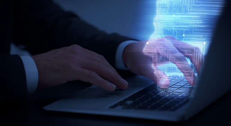 Man using modern laptop at black desk, closeup
