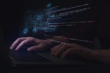 Hacker working with laptop at table, closeup. Cyber attack